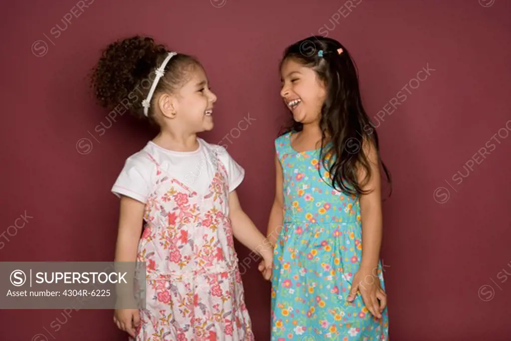 Girls standing face to face, smiling