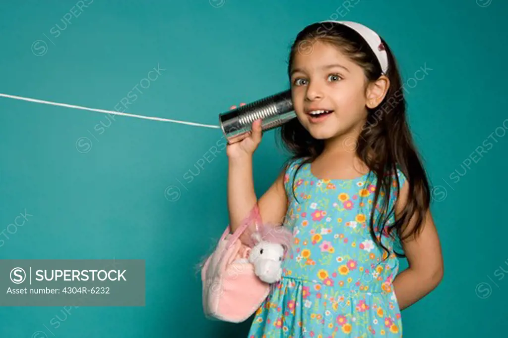 Girl listening through tin can phone, portrait