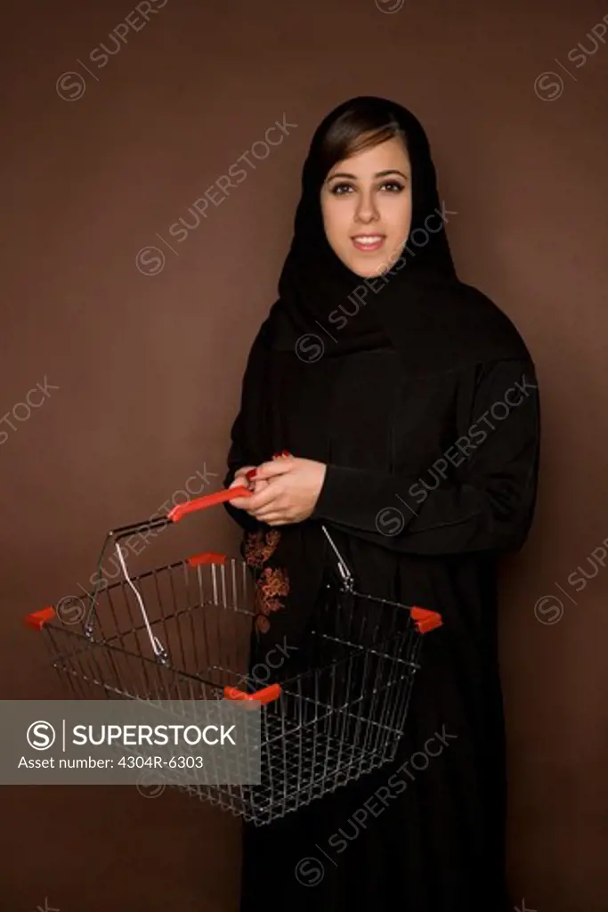 Young woman holding shopping cart, portrait