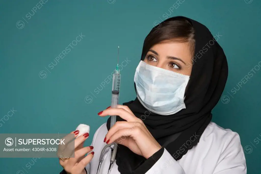 Female doctor with surgical mask and syringe