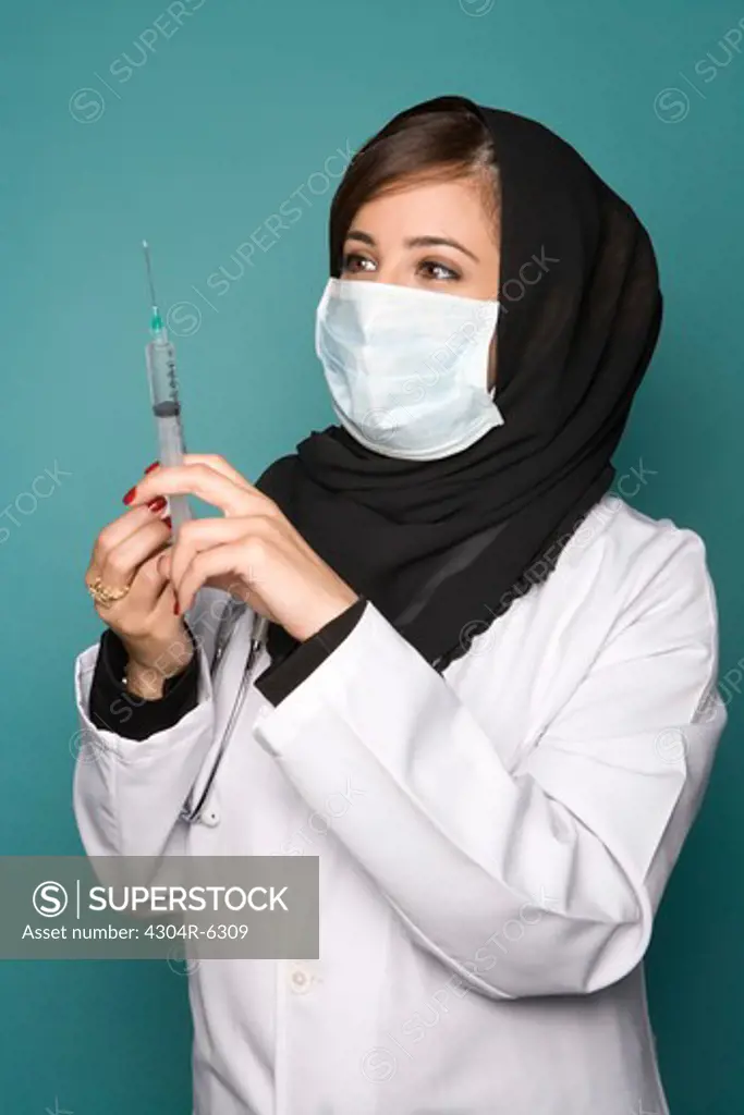 Female doctor with surgical mask and syringe