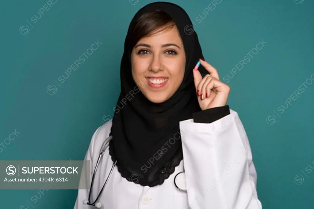 Female doctor holding capsule, portrait