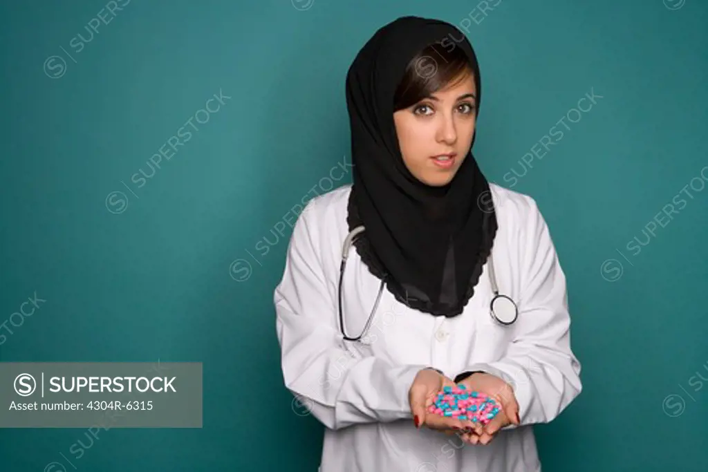 Female doctor holding capsules, portrait