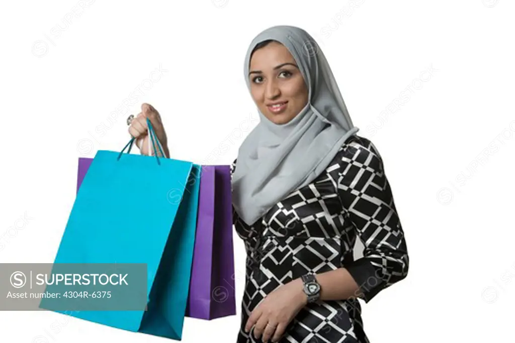 Young woman holding shopping bag, portrait