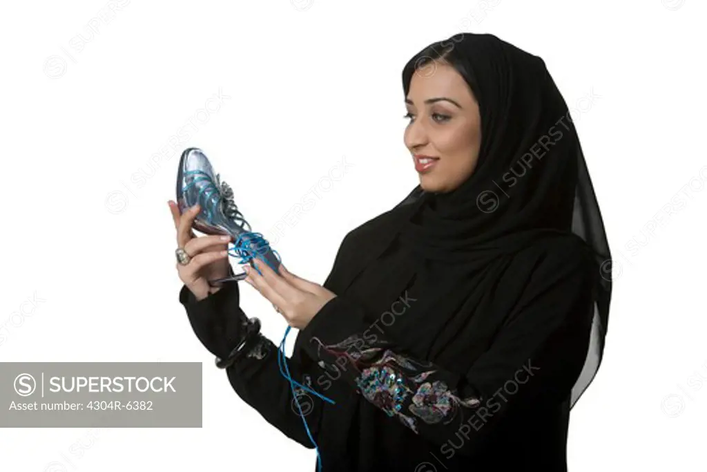 Young woman holding sandal