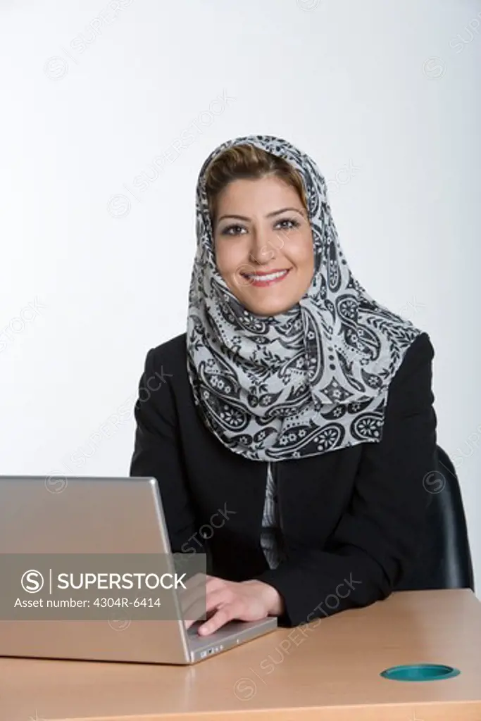 Young woman using laptop, smiling, portrait