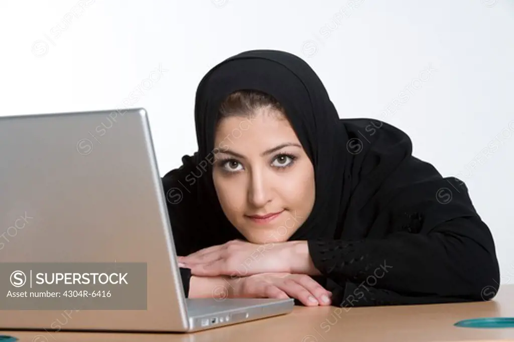 Young woman by laptop, portrait