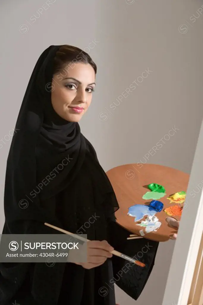Young woman holding palette, painting, portrait