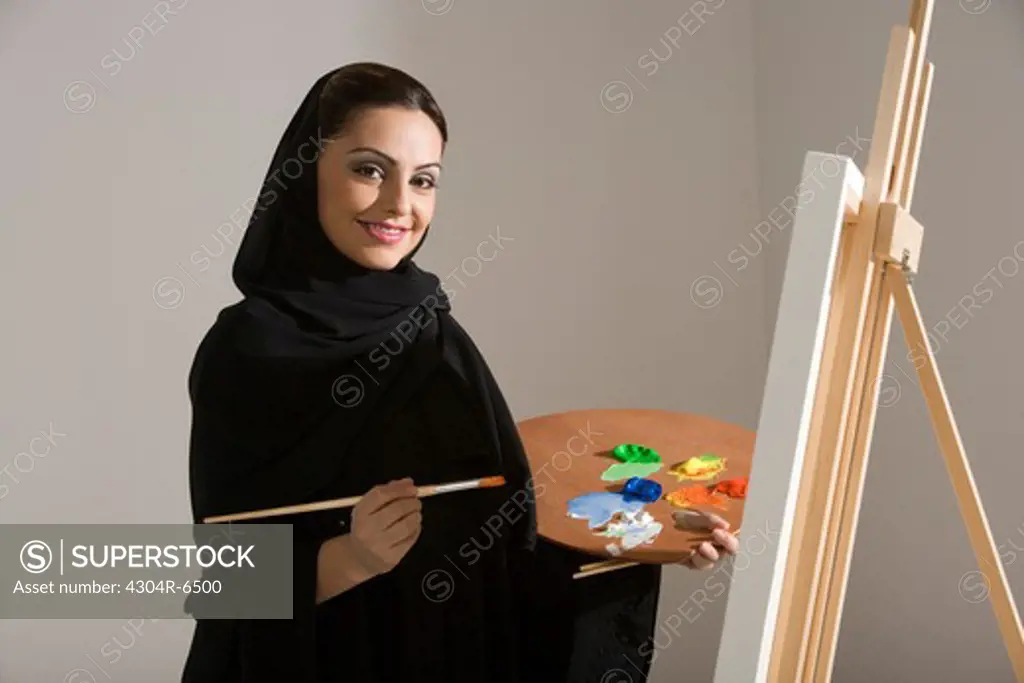 Young woman holding palette, painting, portrait