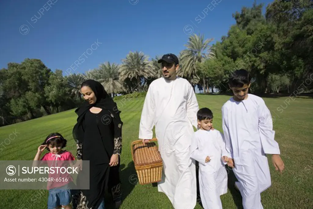 Father and mother with children walking at park