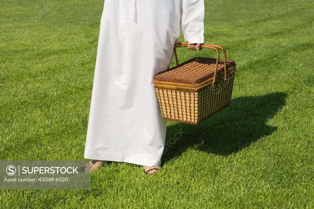Man holding picnic basket, low section
