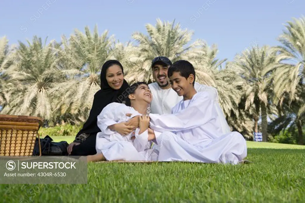 Parents with children enjoying at park, smiling