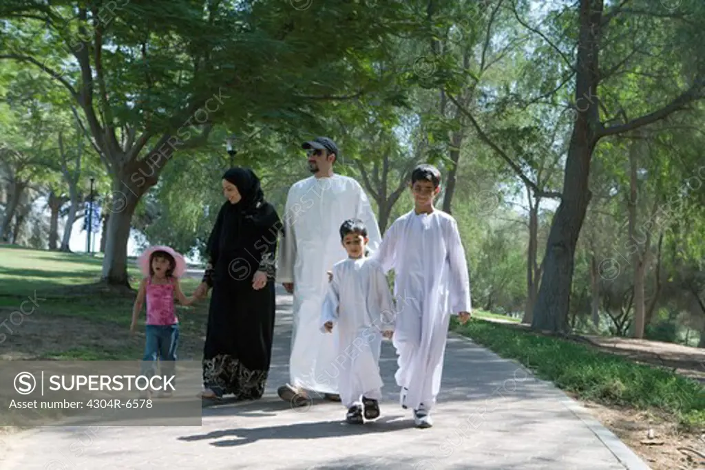 Father and mother with children walking in park