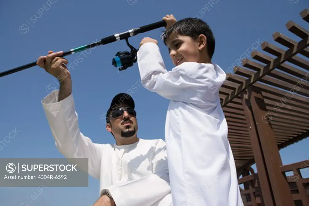 Father with son holding fishing rod
