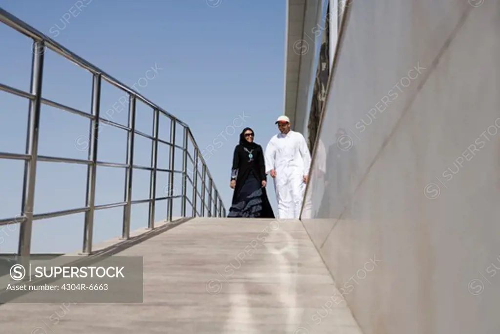 Young couple walking by railing