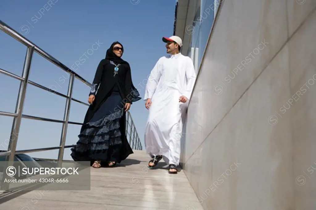 Young couple walking by railing