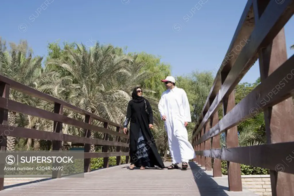 Young couple walking on wooden bridge