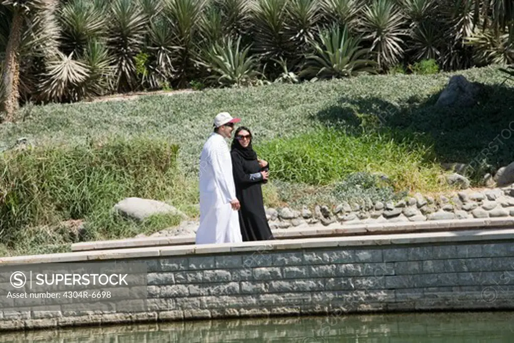 Young couple walking by pond