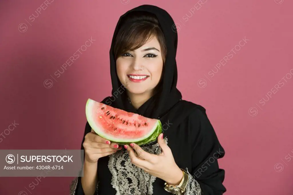 Young woman holding watermelon, portrait
