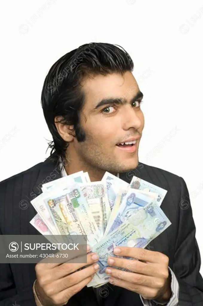 Young man holding paper currency, portrait, close-up