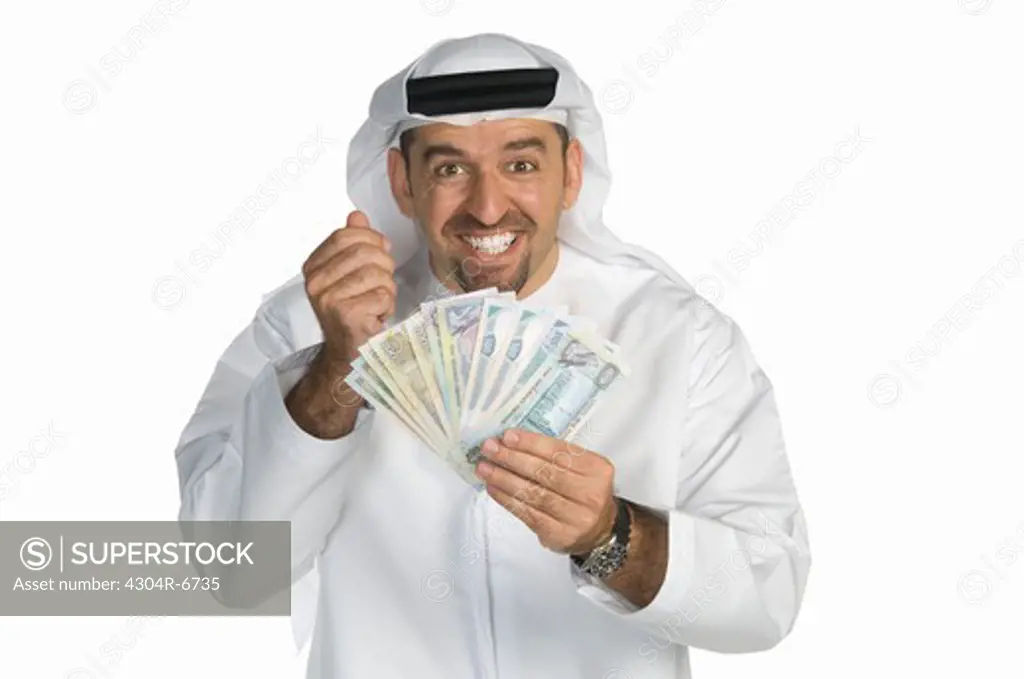 Mid adult man holding paper currency, smiling, portrait