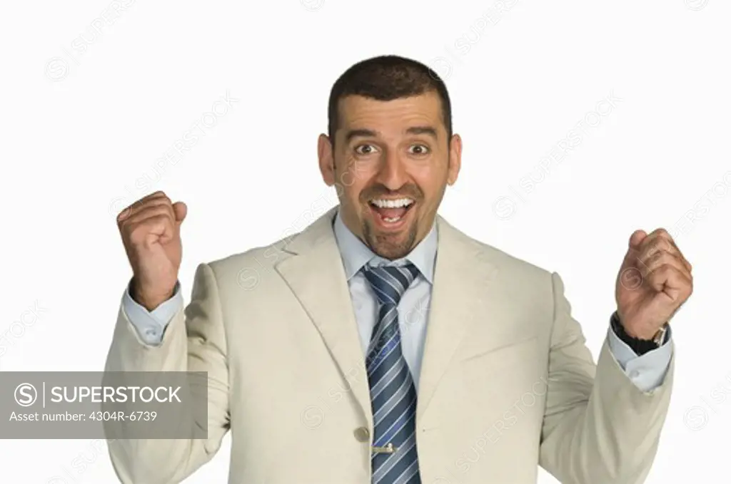 Businessman clenching fists against white background, portrait