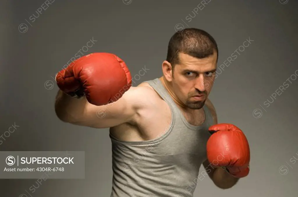 Mid adult man with red boxing gloves