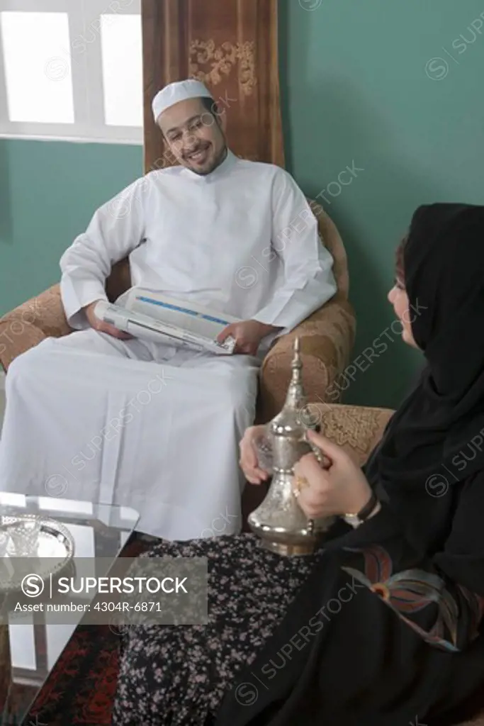 Arab woman serving tea to her husband