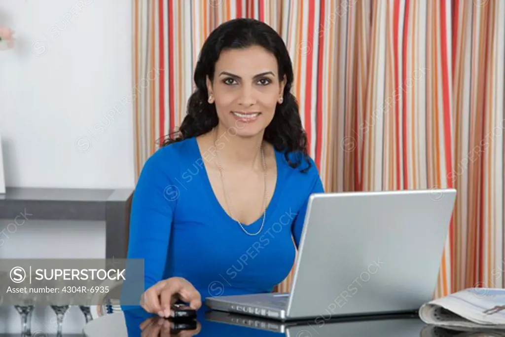 Woman holding her Cellphone at home