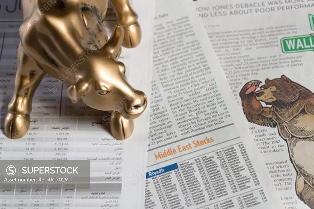 Bull figurine and bear on newspaper, close-up