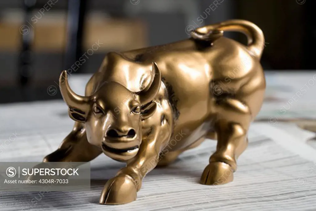 Bull figurine on newspaper, close-up