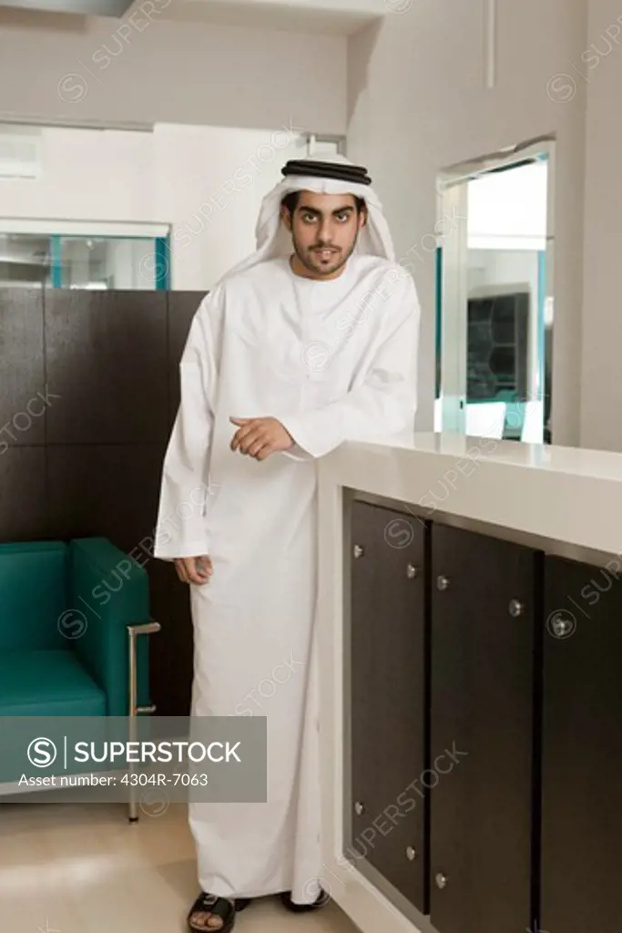 Man standing at reception desk, portrait