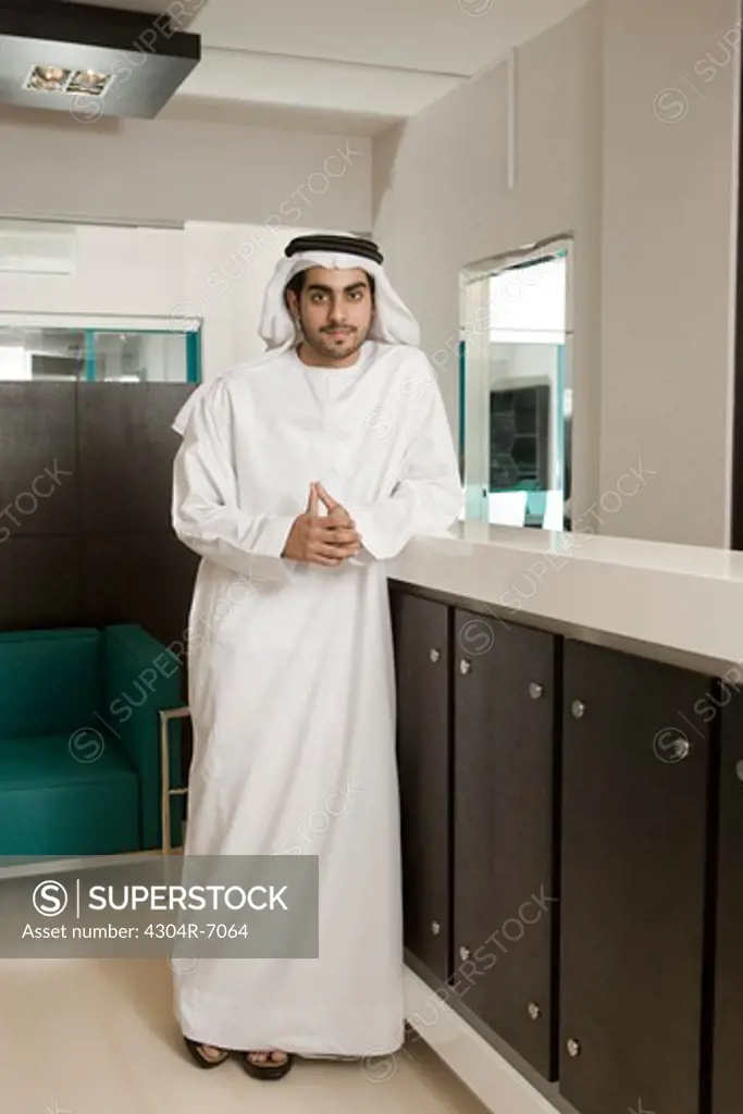 Man standing at reception desk, portrait