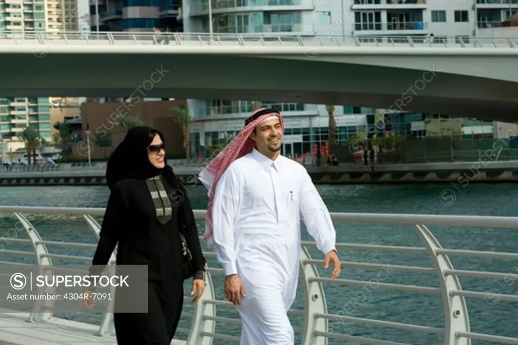 Arab couple walking in Dubai Marina, UAE