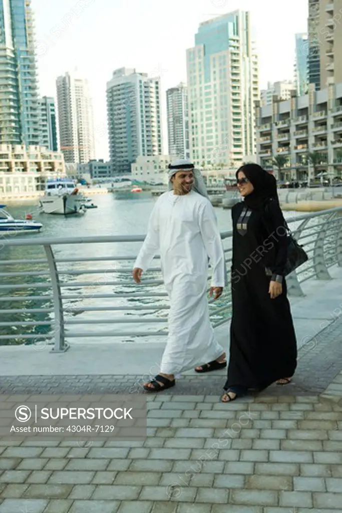 Arab couple walking at Dubai Marina, UAE