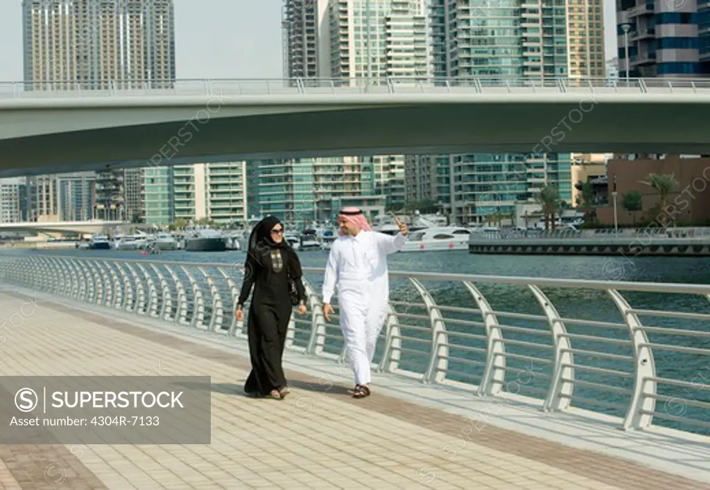 Arab couple walking in Dubai Marina, UAE