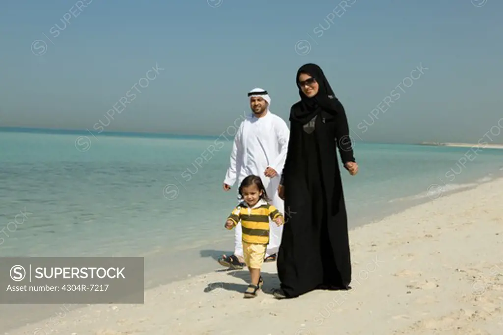 Arab family walking at the beach