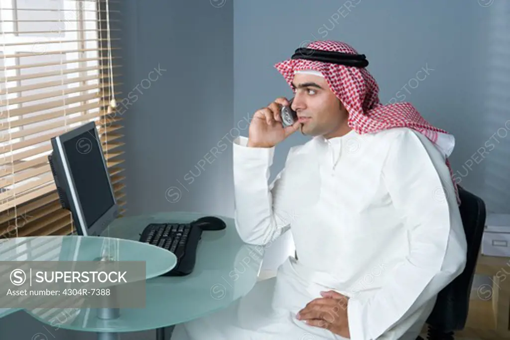 Arab man with cellphone in the office