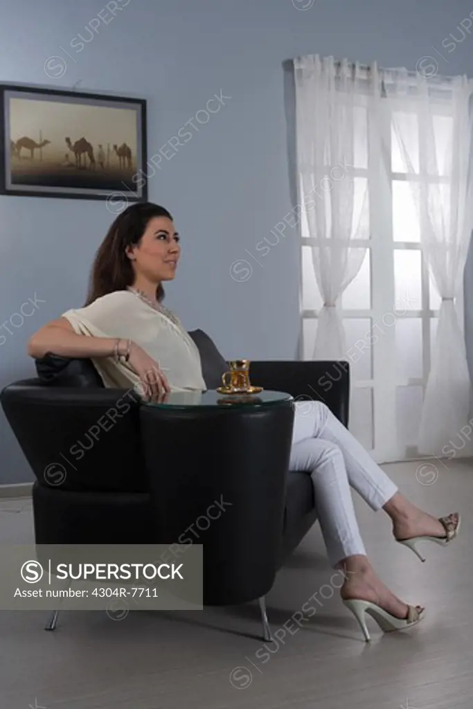Woman with tea cup sitting on a sofa