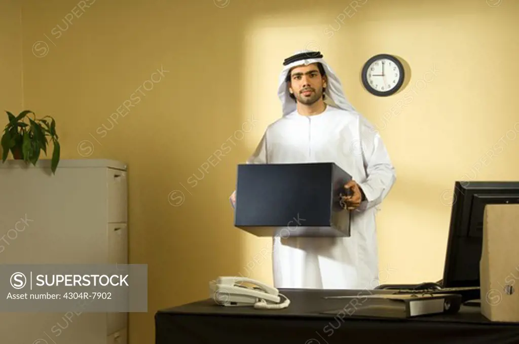 Arab man packing at office desk