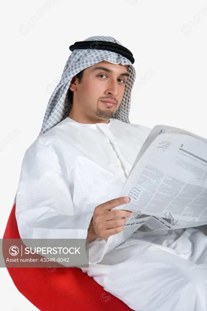Young man holding newspaper, portrait