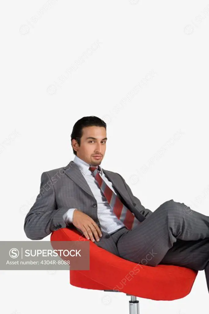 Young businessman sitting on swivel chair, portrait
