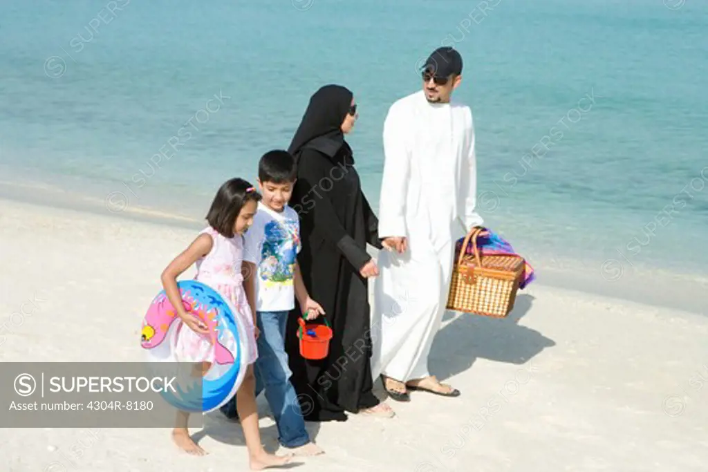 Family walking on beach, smiling