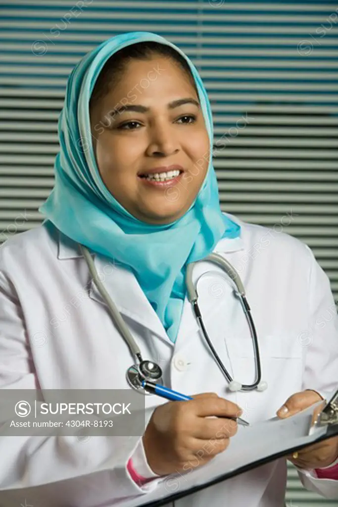 Portrait of a female doctor holding a medical chart.