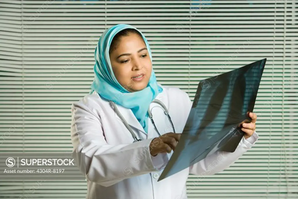 Female doctor holding X-ray, portrait.
