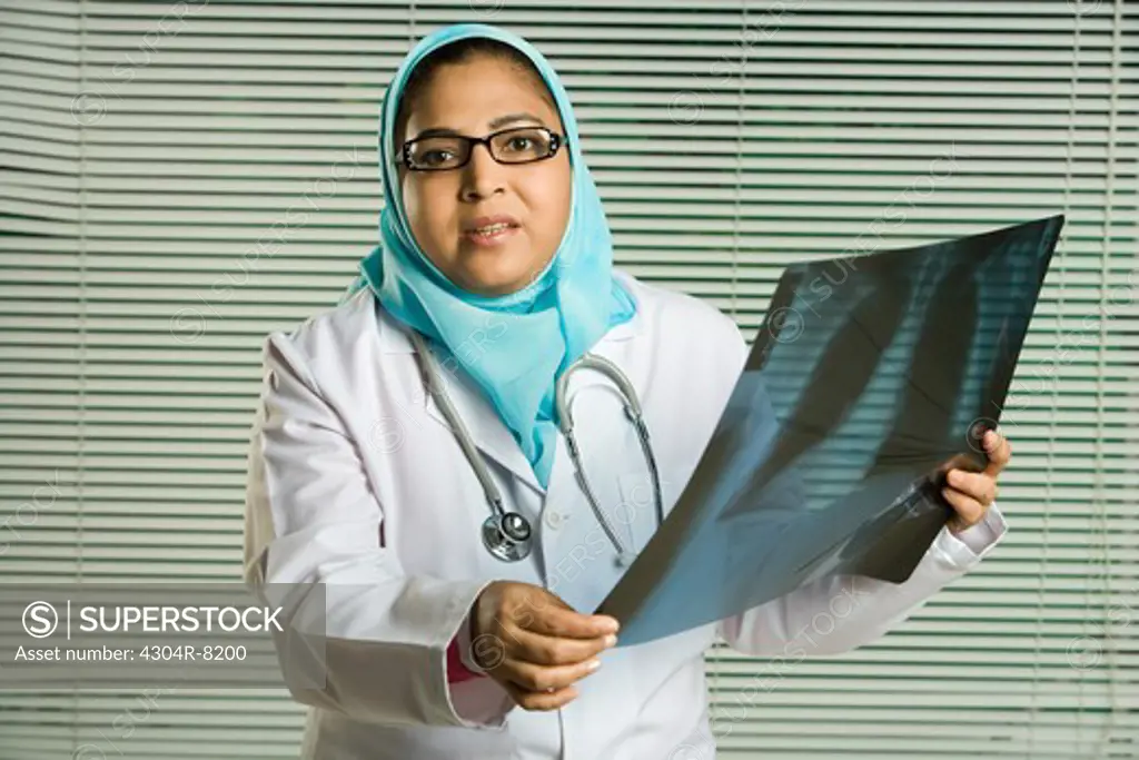 Female doctor holding X-ray, portrait.