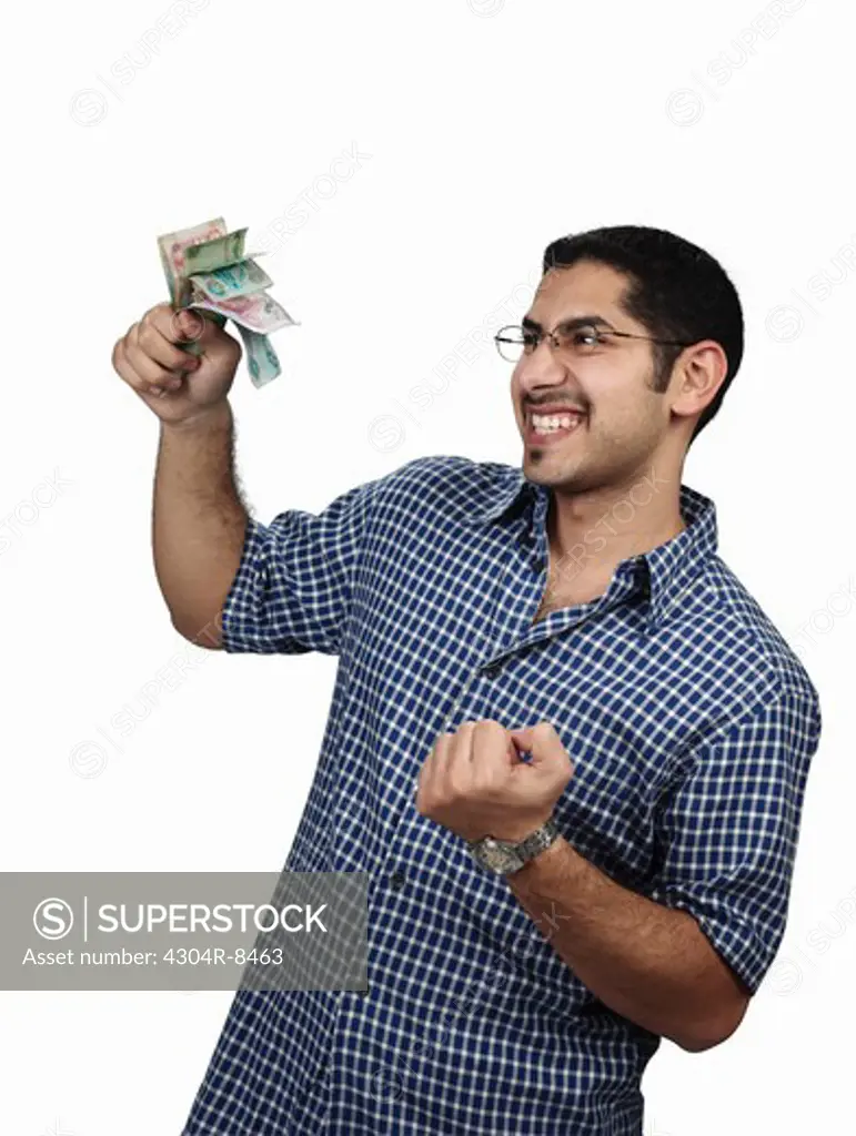 Young man holding money with a happy expression