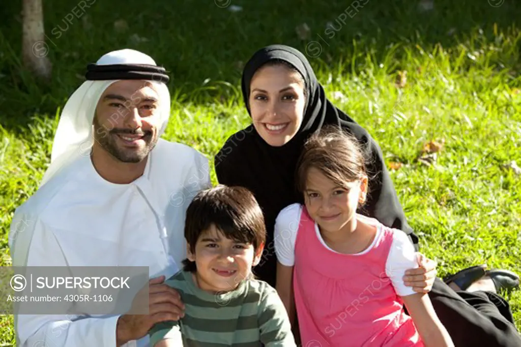 Portrait of an arab family having picnic at the park, smiling.