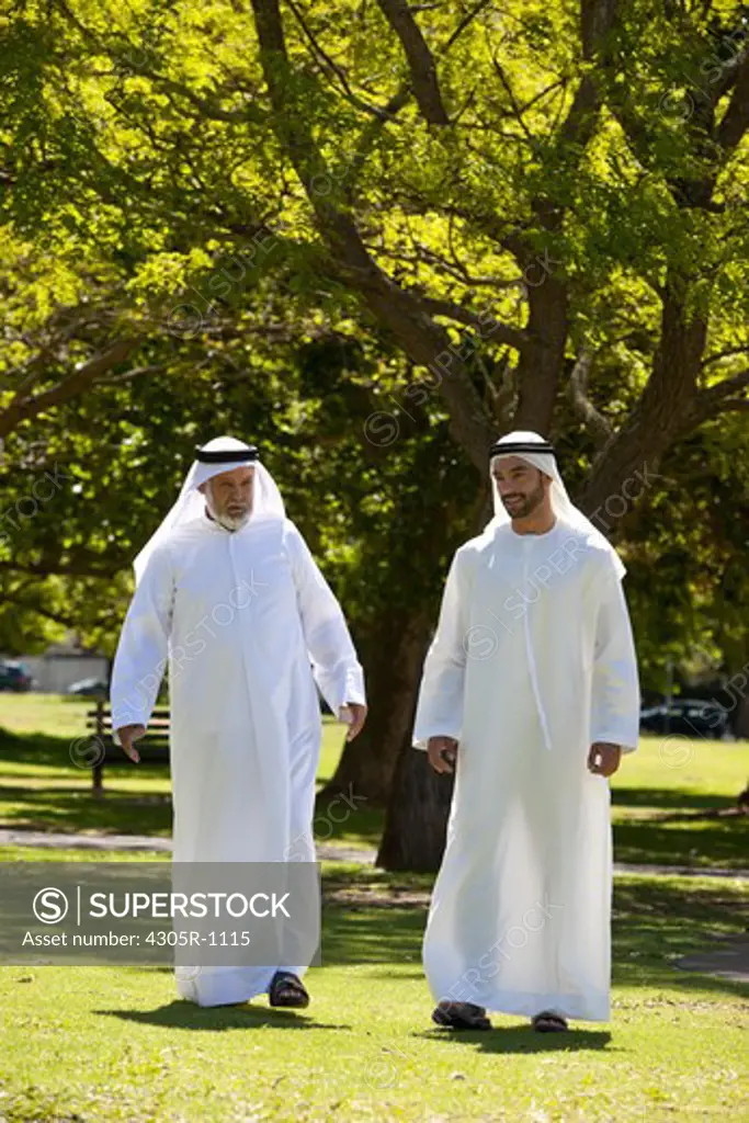 Arab father and son walking together at the park.