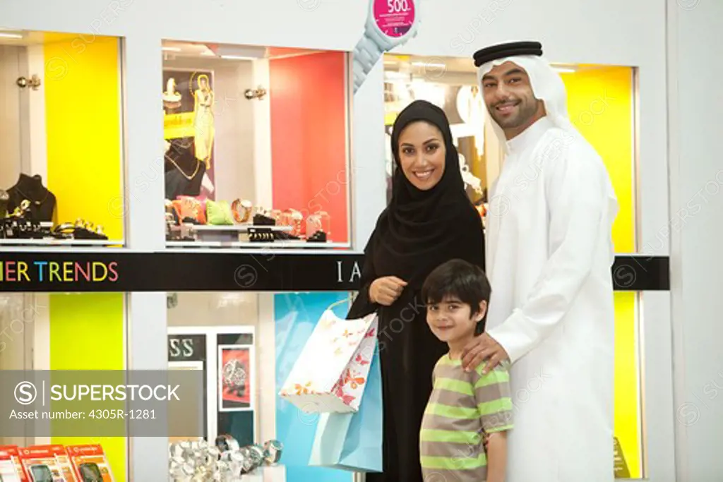 Portrait of arab family standing at the shopping mall, smiling.